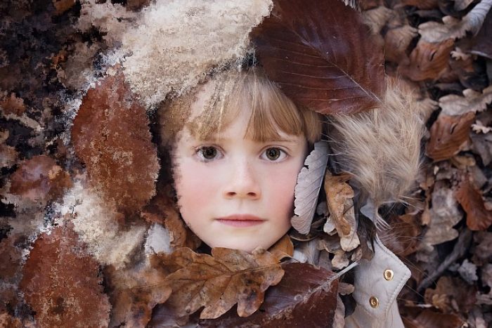 Retrato de un niño sobre hojas de otoño