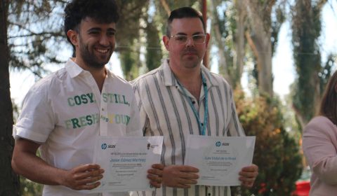 Premiados con los diplomas Dos premiados sostienen sus diplomas de reconocimiento.