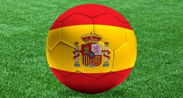 Un balón con la bandera de España sobre el césped de un campo de fútbol