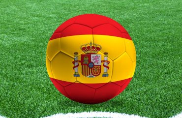Un balón con la bandera de España sobre el césped de un campo de fútbol