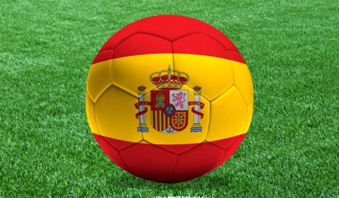 Un balón con la bandera de España sobre el césped de un campo de fútbol